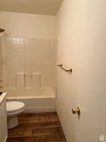 Full bath featuring dark wood finished floors, shower / bathtub combination, and vanity