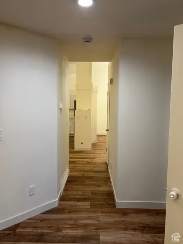 Hall with dark wood-style flooring and recessed lighting
