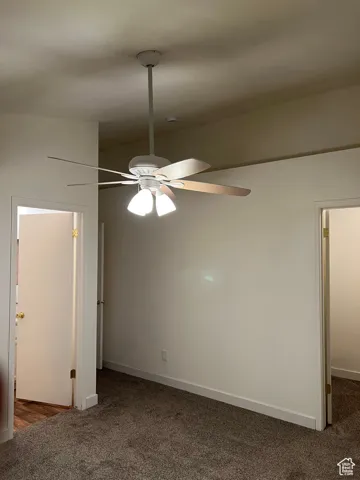 Unfurnished Master bedroom featuring dark carpet and a ceiling fan