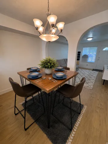Dining area featuring a decorative chandelier with frosted glass shades,and new LVP light wood flooring