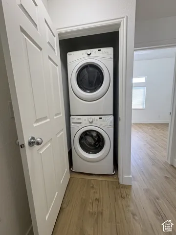 Dedicated laundry closet featuring a stacked white front-load washer and dryer set.