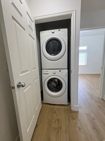 Dedicated laundry closet featuring a stacked white front-load washer and dryer set.