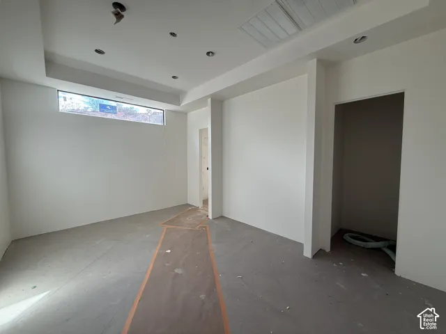 Interior space featuring a recessed tray ceiling, clerestory window, and recessed lighting