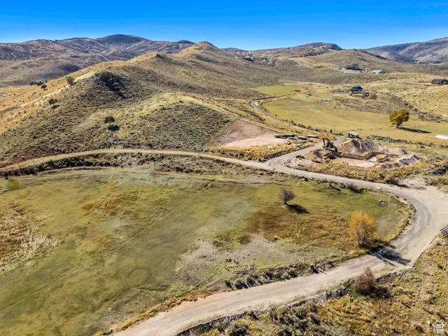 Aerial view of property and surrounding area featuring mountains and rural landscape