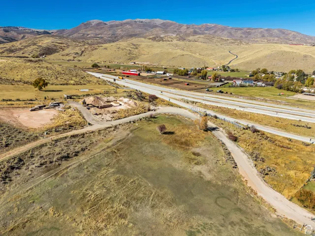 Aerial view of property and surrounding area with a mountainous background