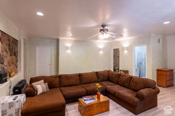 Living room featuring light wood-style flooring, a ceiling fan, and recessed lighting