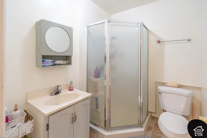 Full bath with vanity, a shower stall, and light tile patterned floors