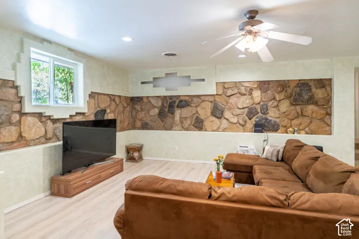 Living area with wood finished floors, recessed lighting, and a ceiling fan