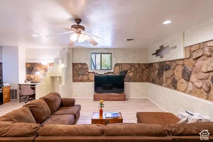 Living room featuring an office area, light wood-style floors, and ceiling fan