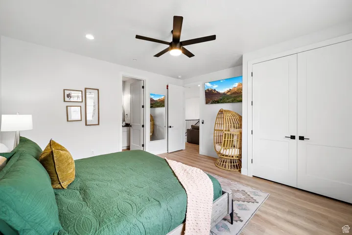 Bedroom with light wood-type flooring, ceiling fan, recessed lighting, ensuite bathroom, and a closet