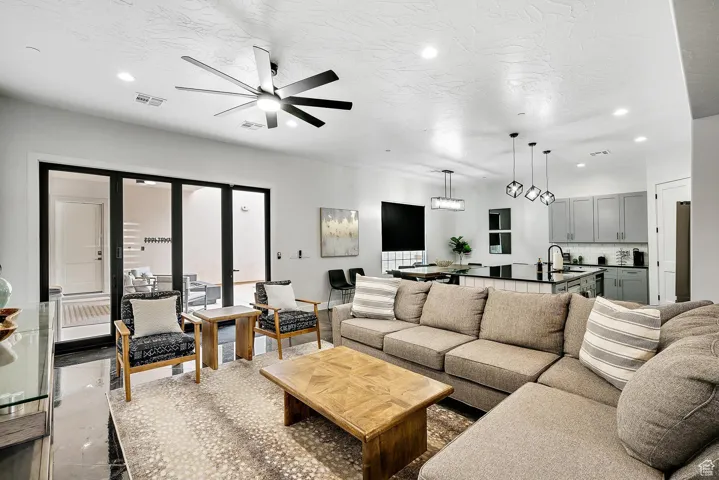 Living room featuring recessed lighting, a ceiling fan, and a textured ceiling