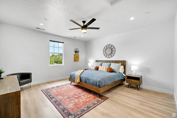 Bedroom featuring light wood finished floors, ceiling fan, and recessed lighting