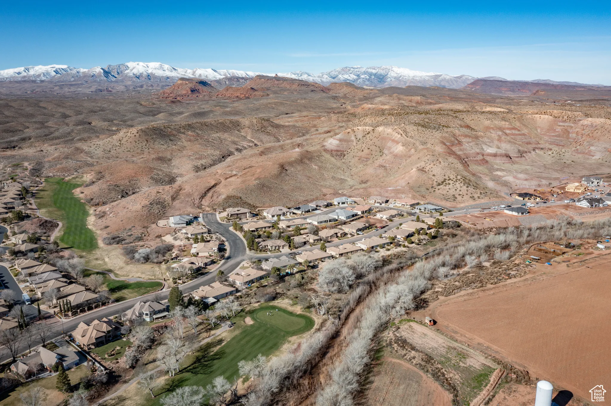 Aerial overview of property's location with a mountainous background and nearby suburban area
