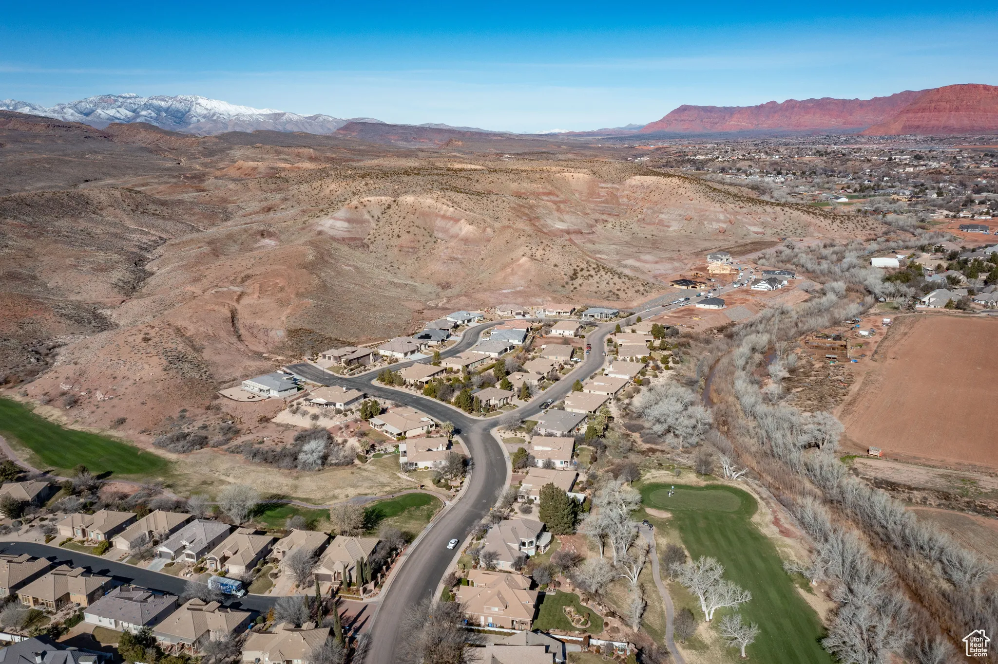 Aerial view of property's location with a mountain backdrop, nearby suburban area, and a local golf course