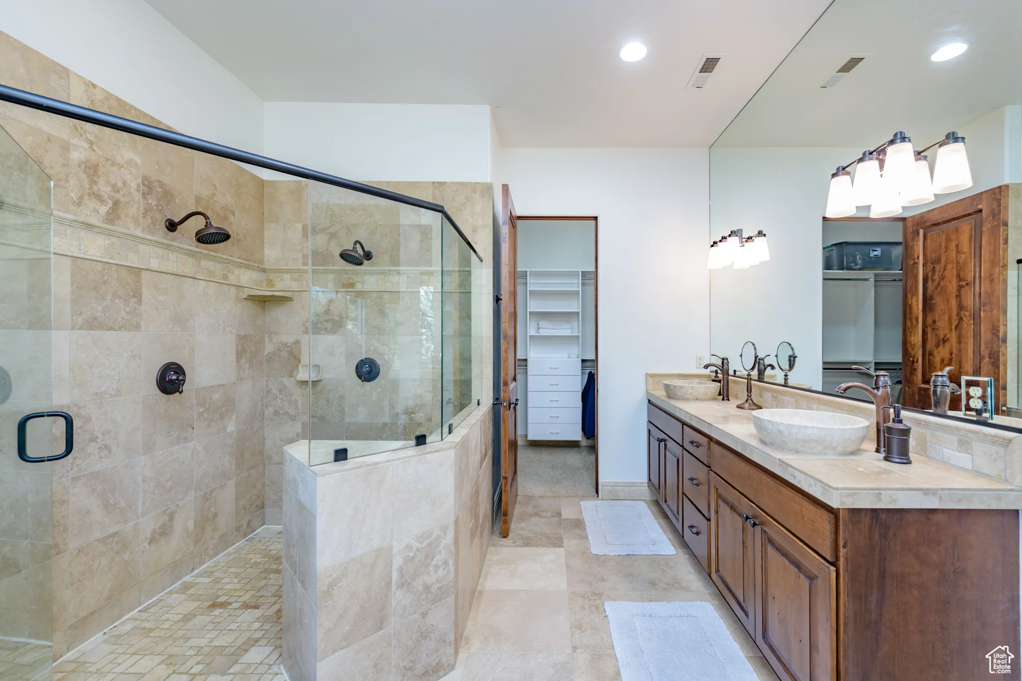 Full bathroom with a walk in closet, double vanity, a shower stall, recessed lighting, and light tile patterned flooring