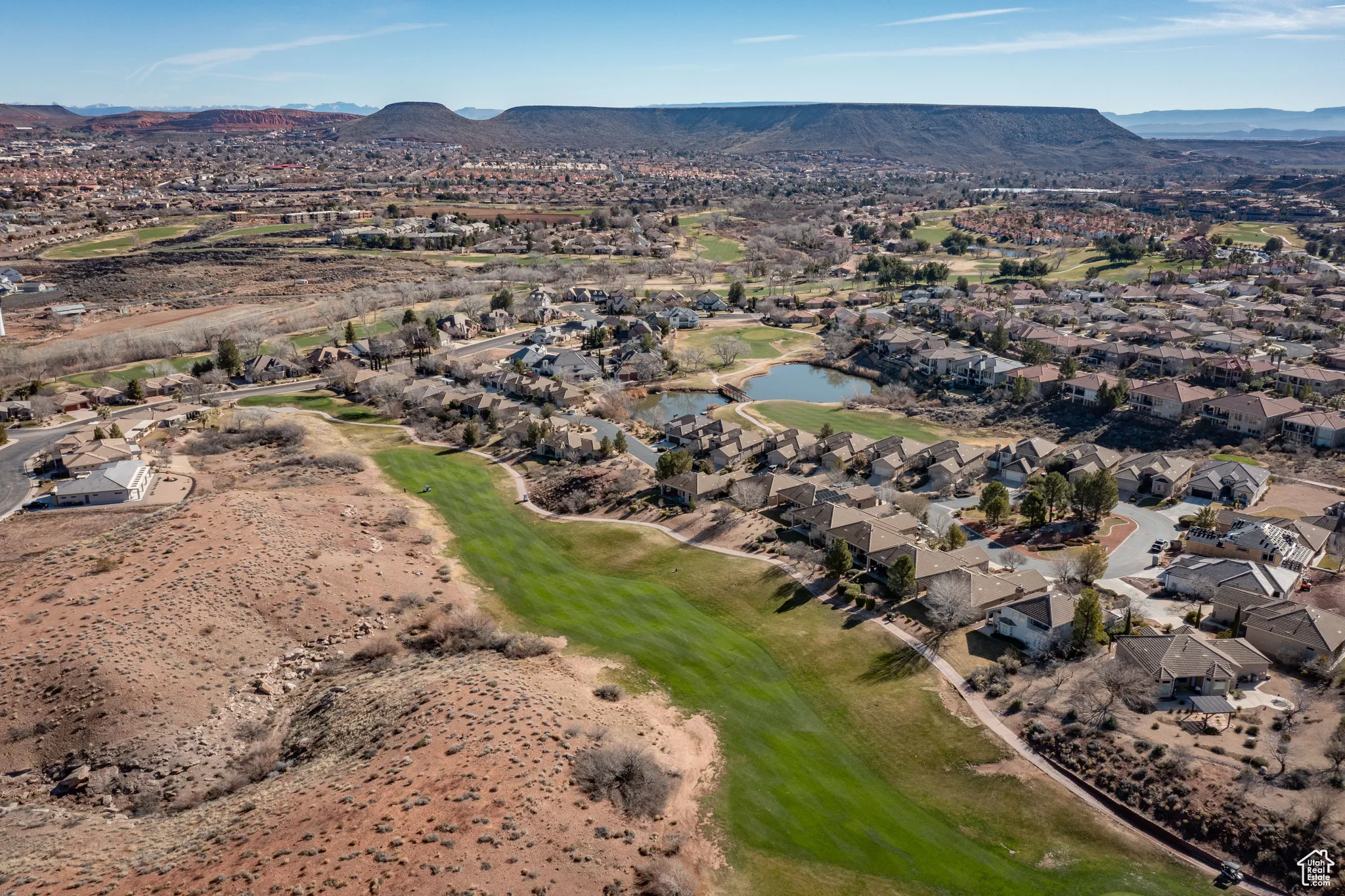 View of property location with a water and mountain view, nearby suburban area, and a golf club