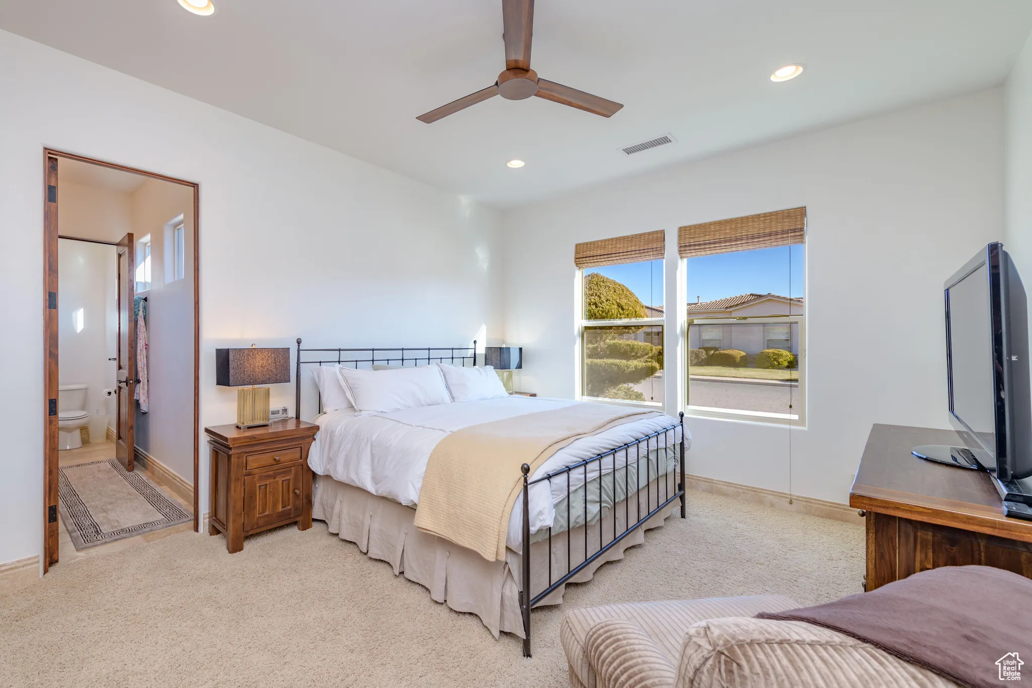 Carpeted bedroom with recessed lighting, connected bathroom, and ceiling fan