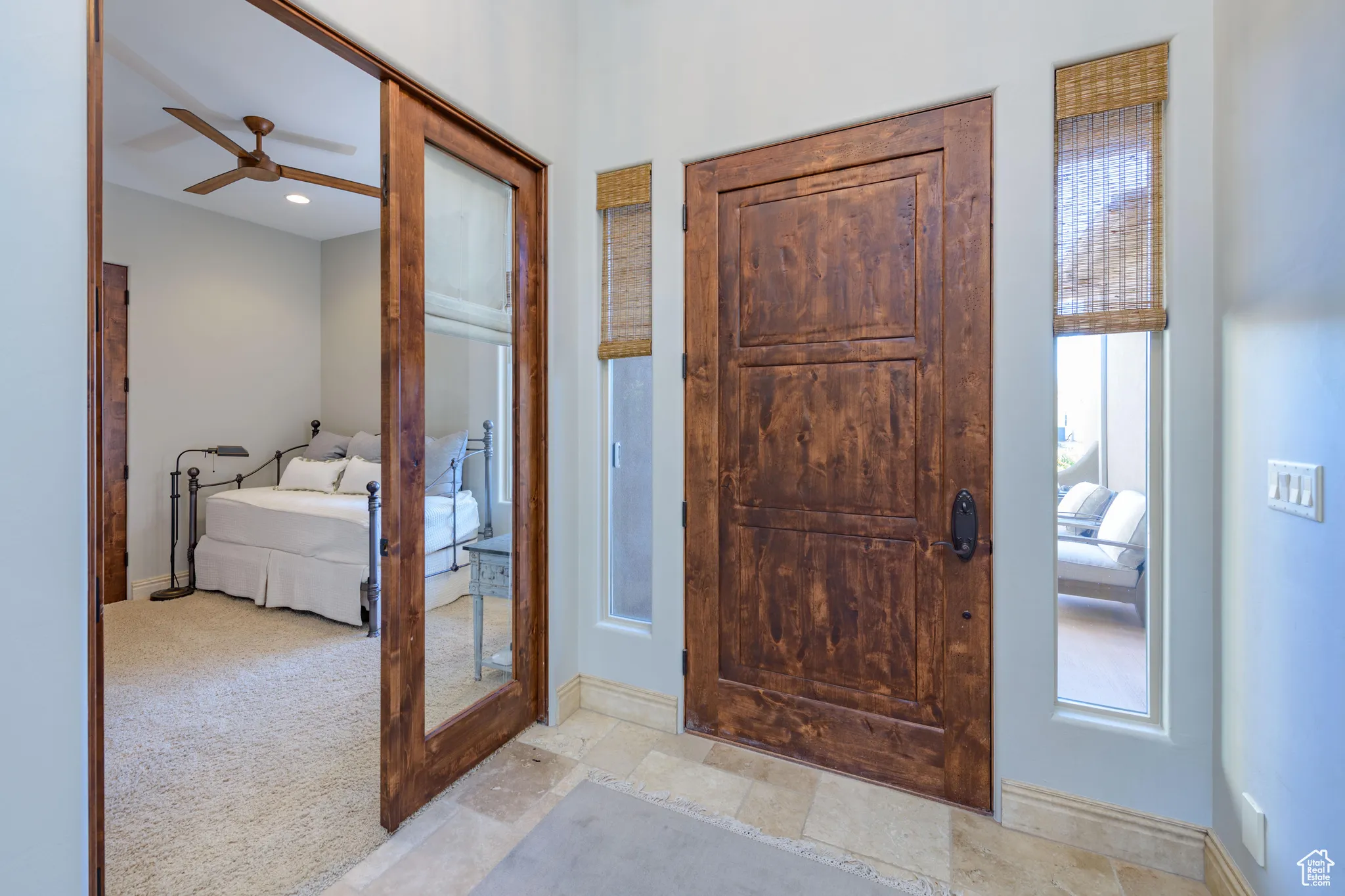 Foyer entrance with carpet floors and ceiling fan