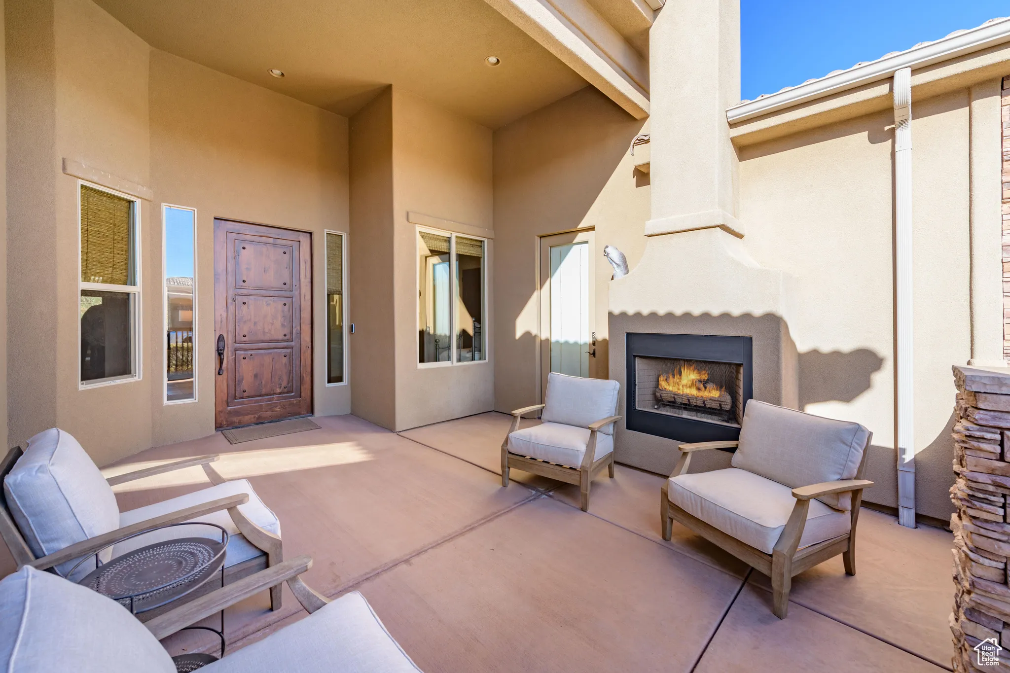 View of patio featuring a warm lit fireplace