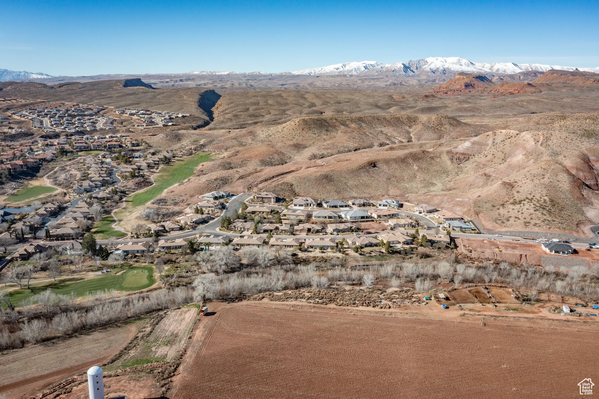 Aerial view of property and surrounding area with nearby suburban area and mountains