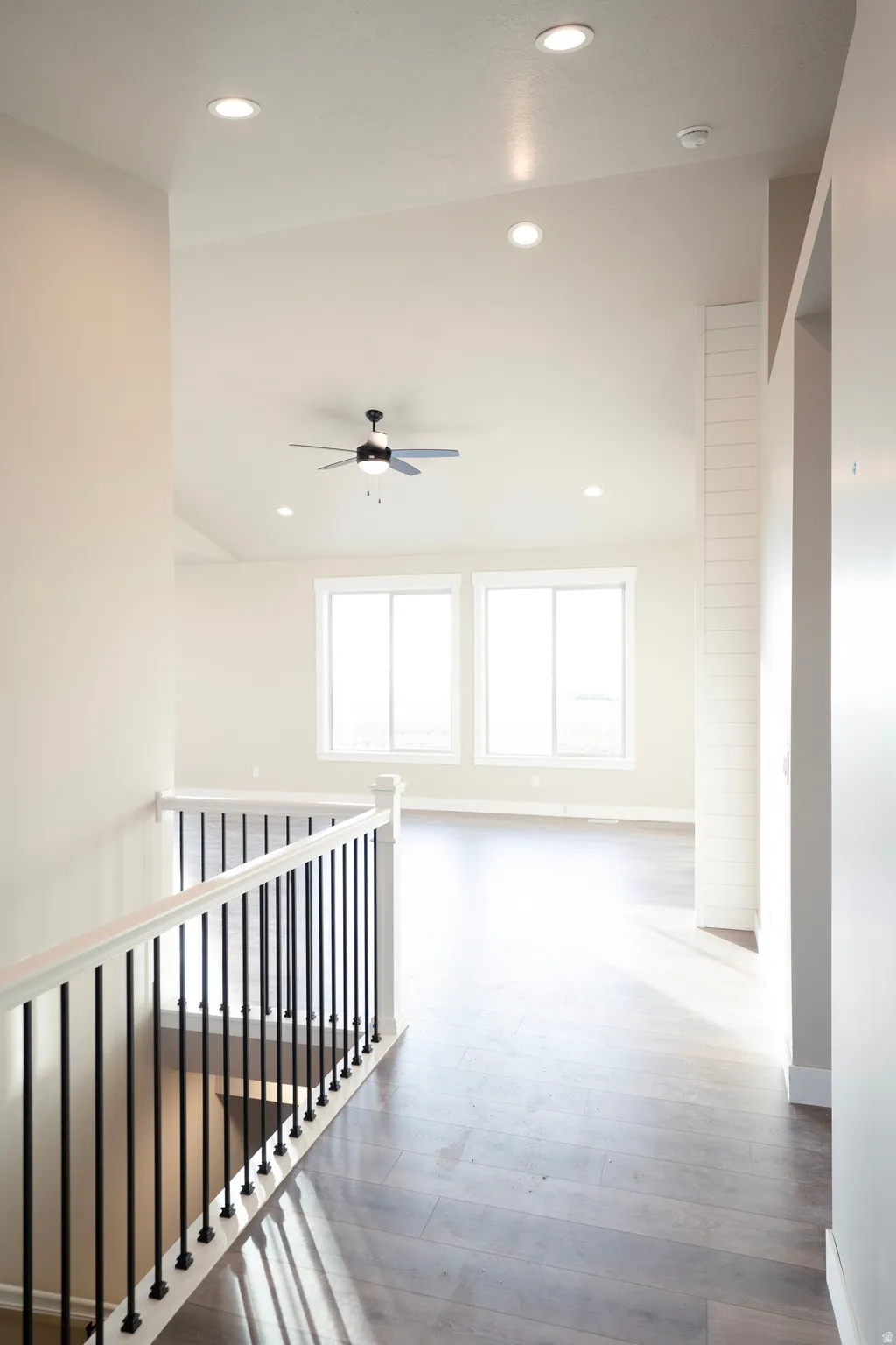 Corridor featuring recessed lighting, light wood-style flooring, and an upstairs landing