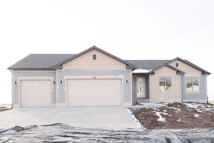 View of front of home featuring driveway, a garage, roof with shingles, and board and batten siding