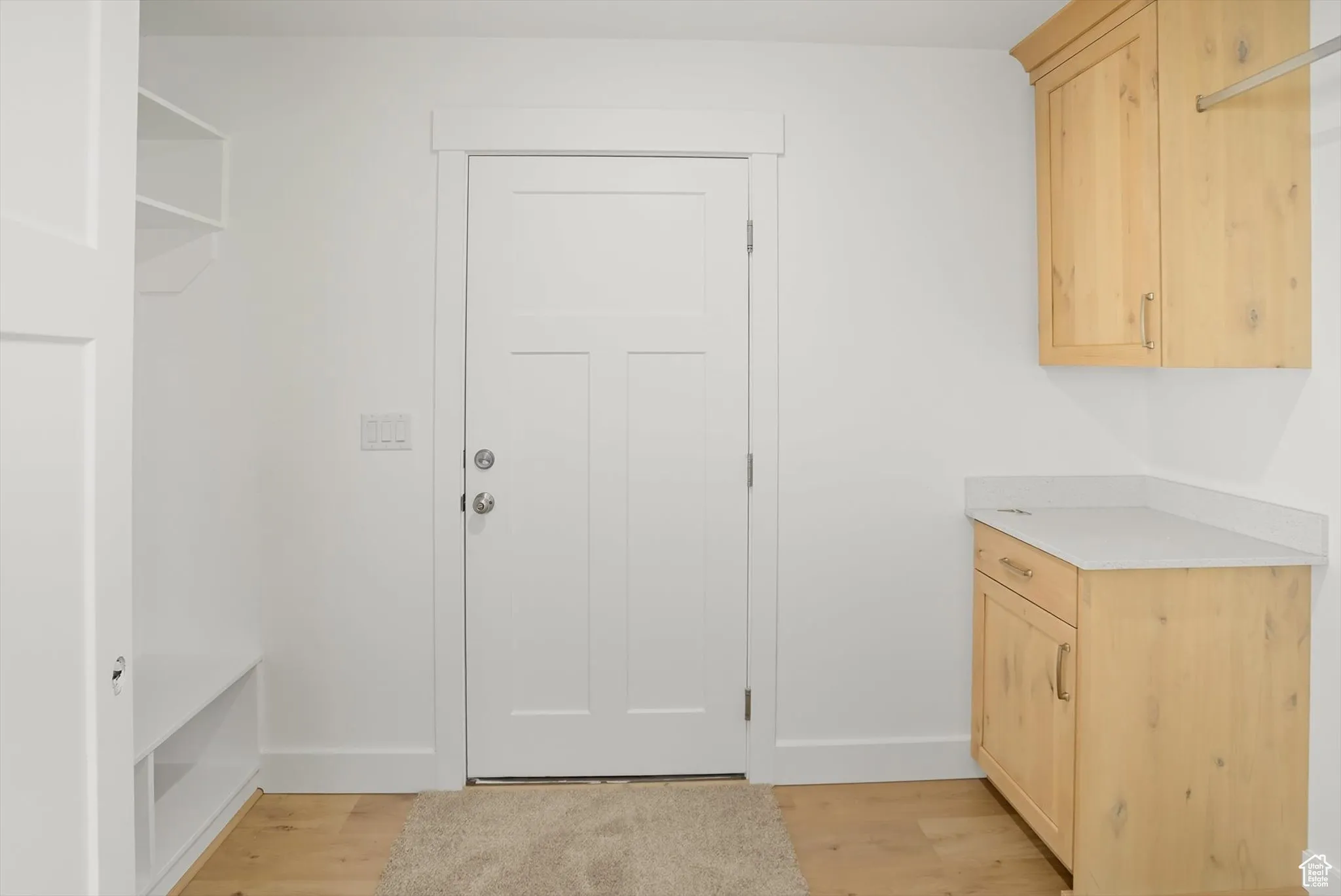 Laundry area featuring light wood-style floors and baseboards