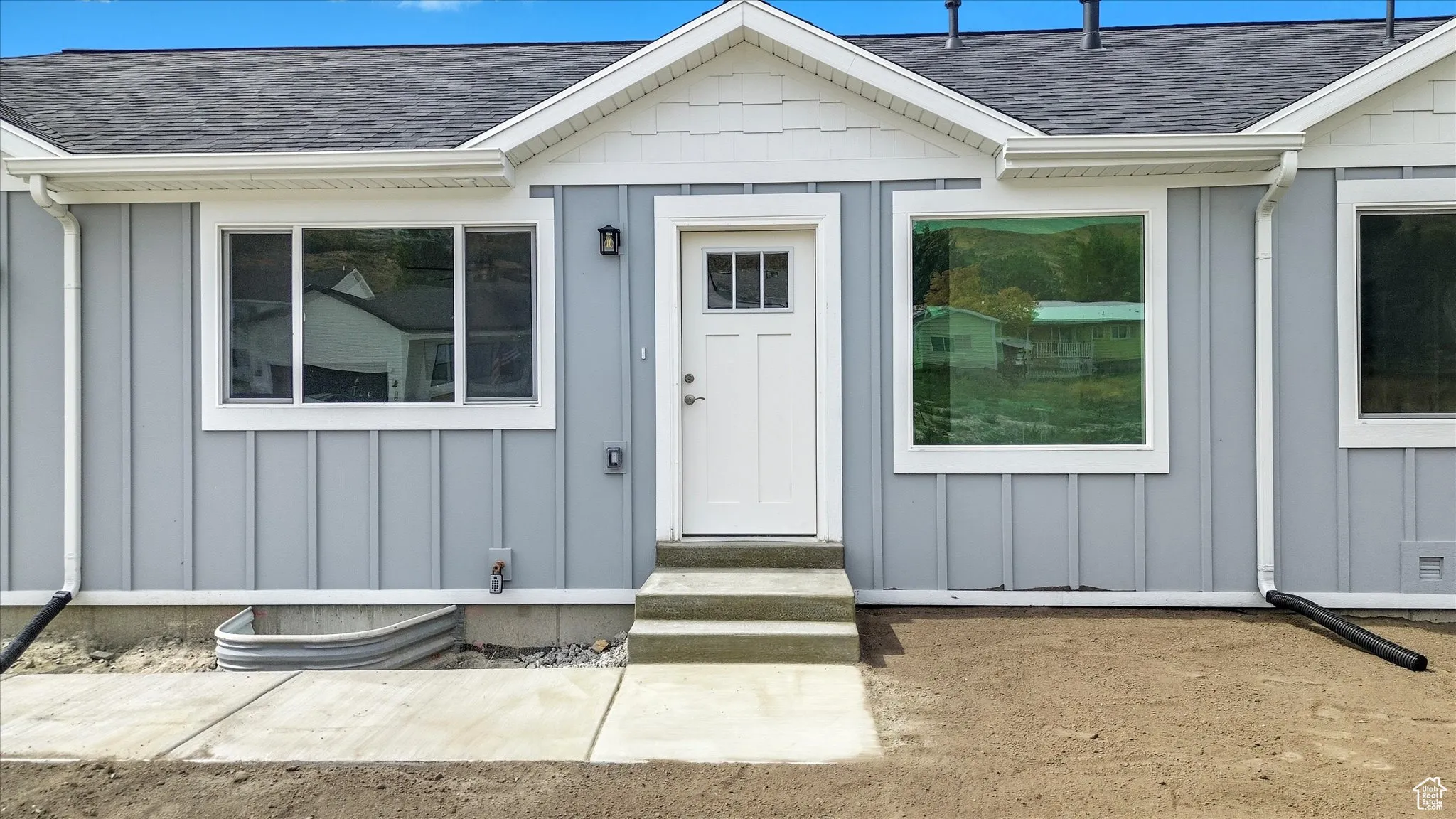 Property entrance featuring board and batten siding and roof with shingles