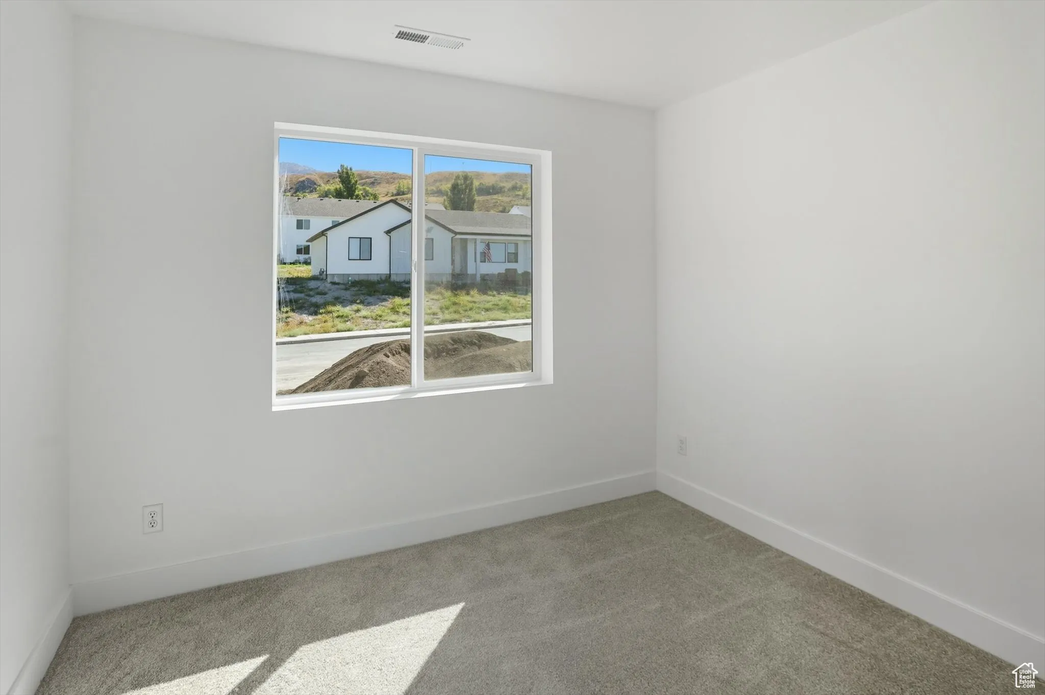 Empty room with light carpet and baseboards