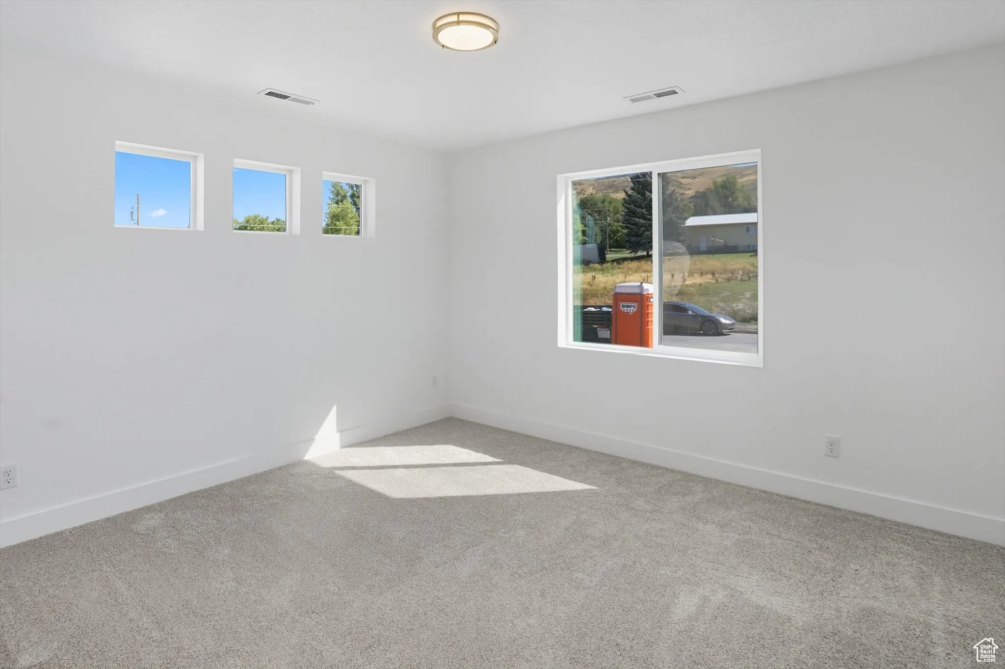 Carpeted empty room with baseboards