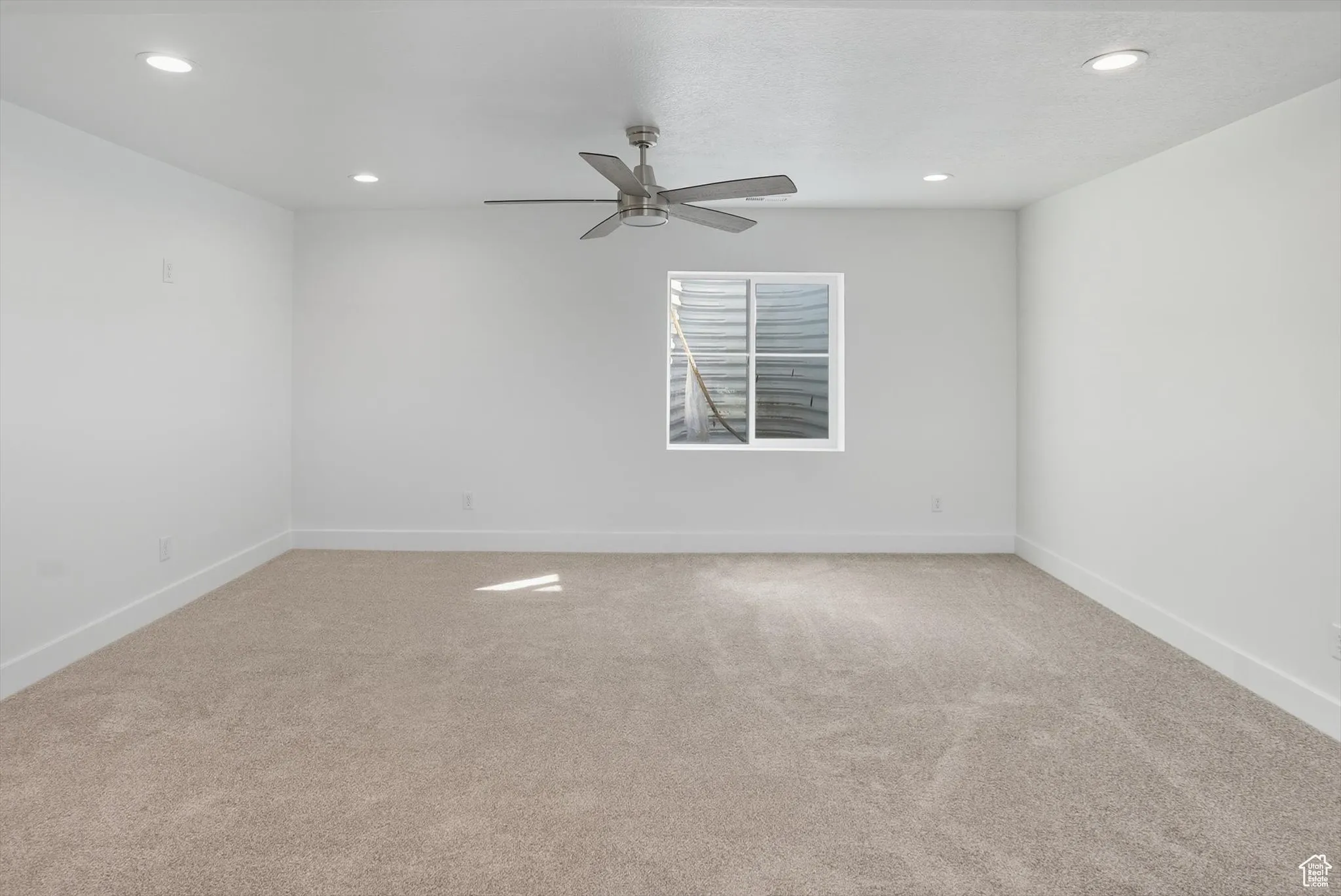 Empty room featuring light carpet, recessed lighting, and a ceiling fan