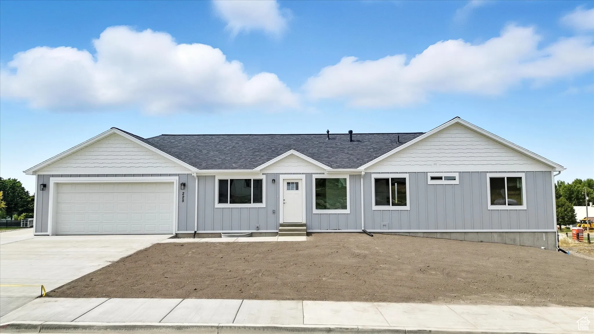 View of front of house featuring concrete driveway, board and batten siding, roof with shingles, and a garage