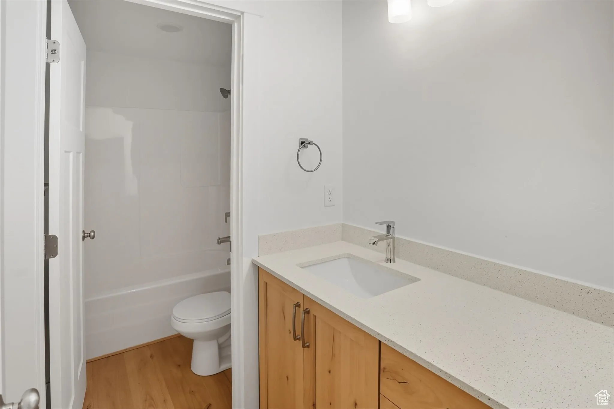 Bathroom featuring vanity, light wood-style floors, and shower / tub combination