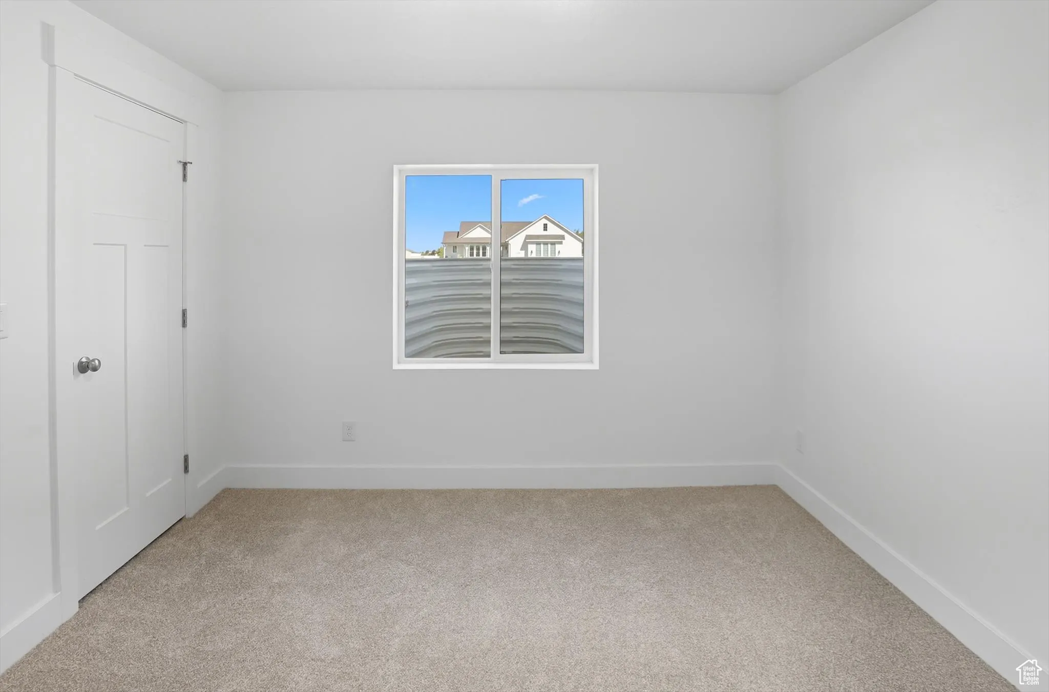 Unfurnished bedroom featuring light colored carpet and baseboards