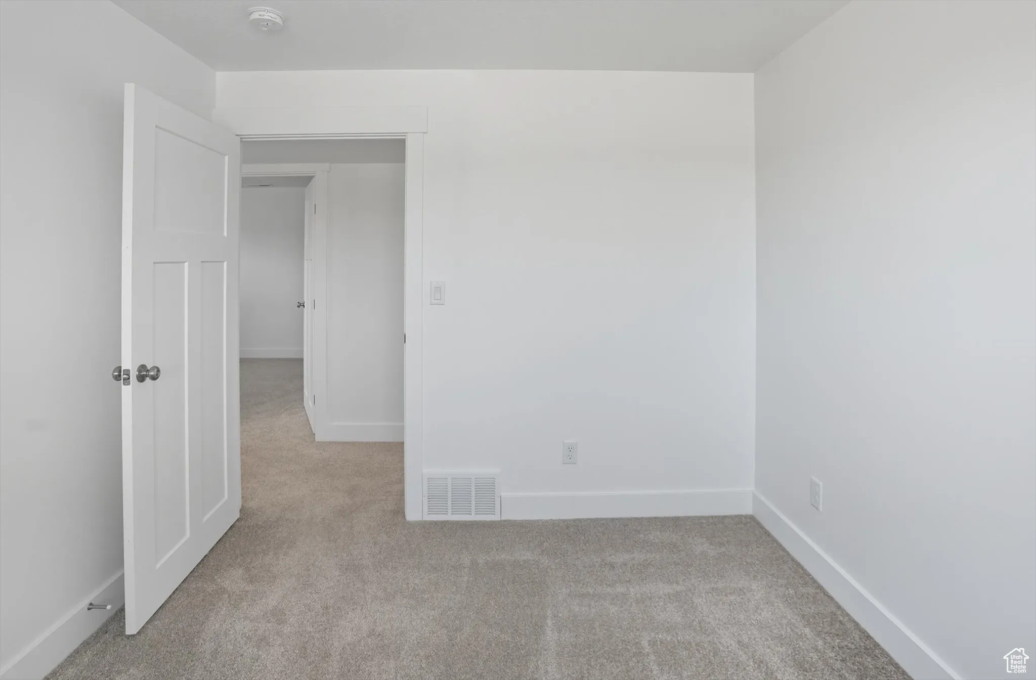 Spare room with light carpet and baseboards