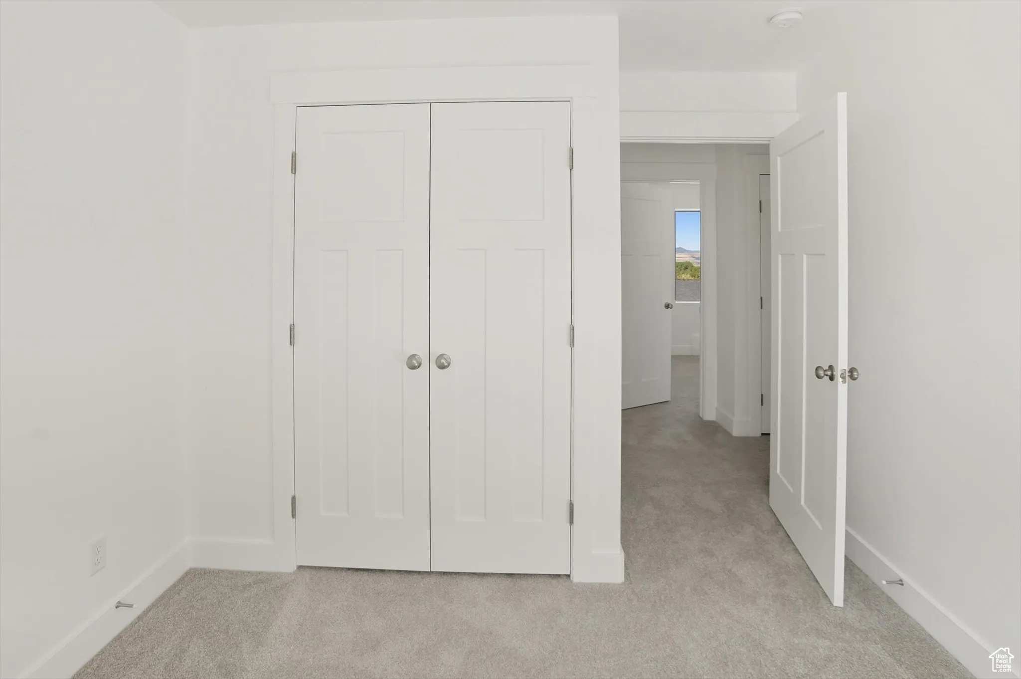 Unfurnished bedroom with light carpet and a closet