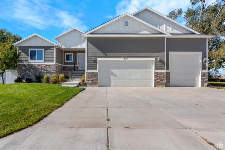 Craftsman-style home with stone siding, board and batten siding, and a front yard