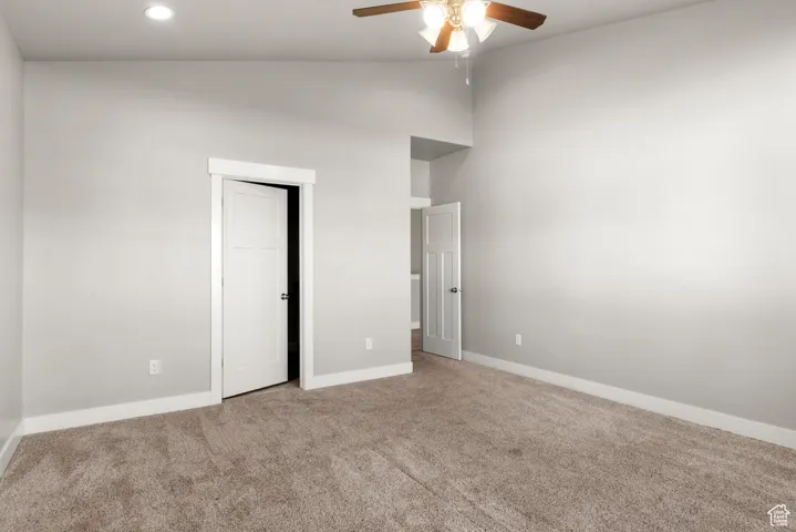 Unfurnished bedroom featuring carpet flooring, a ceiling fan, a closet, recessed lighting, and high vaulted ceiling