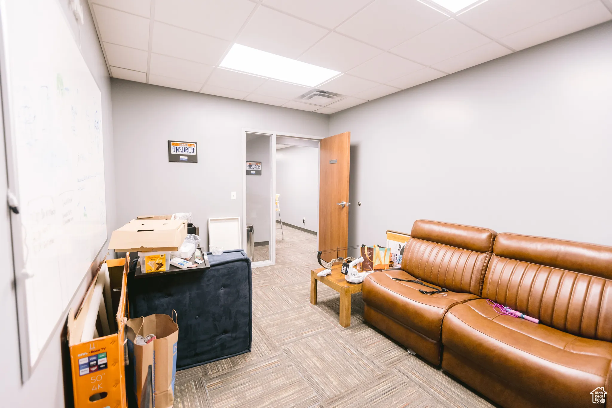 Living room with carpet flooring and a paneled ceiling