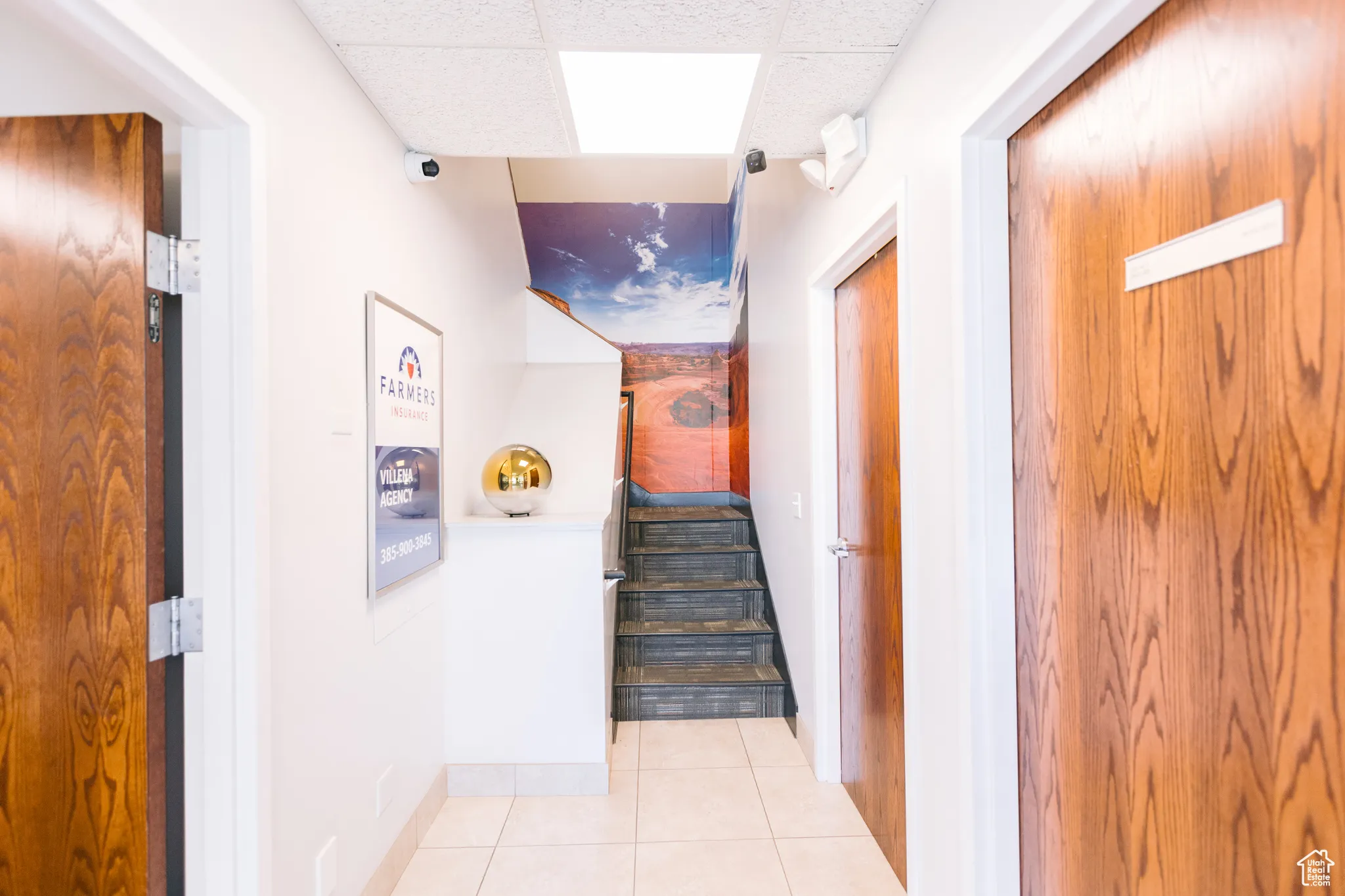 Hall with tile patterned flooring, stairway, a paneled ceiling, and elevator