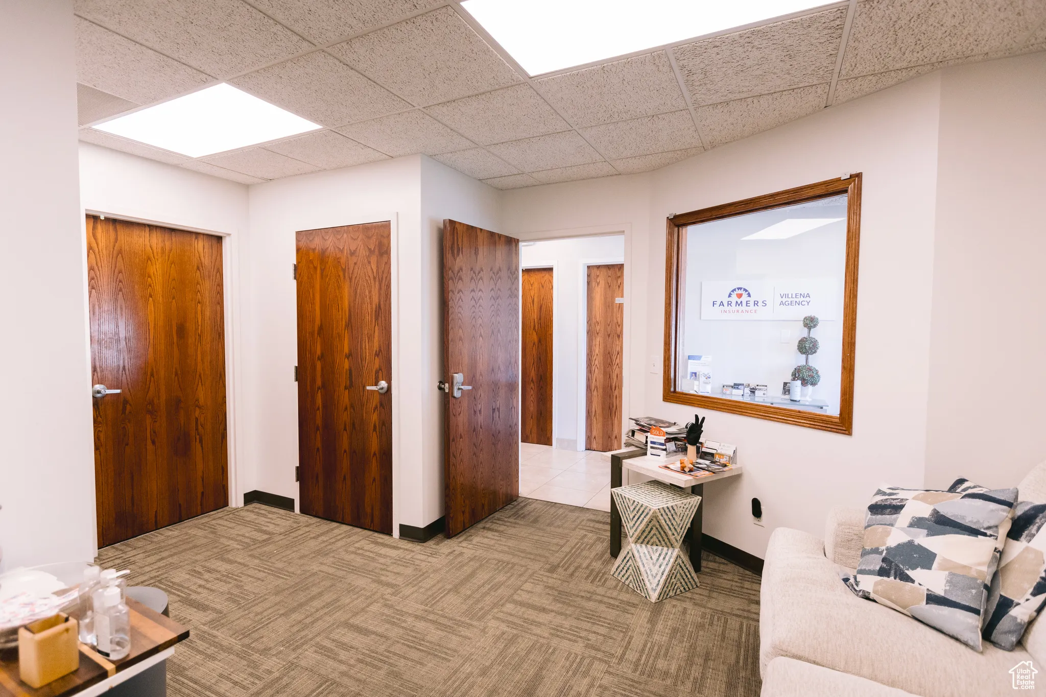Hallway with carpet floors and a drop ceiling