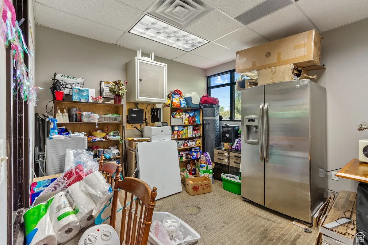 Kitchen featuring stainless steel fridge and a paneled ceiling