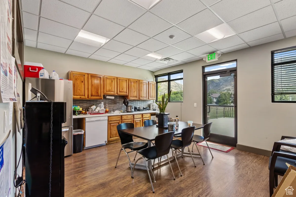 Dining area with a paneled ceiling and dark wood-type flooring