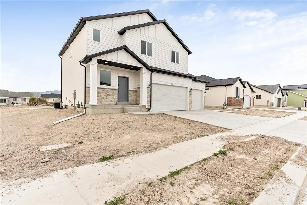Modern farmhouse with an attached garage, driveway, a residential view, and board and batten siding