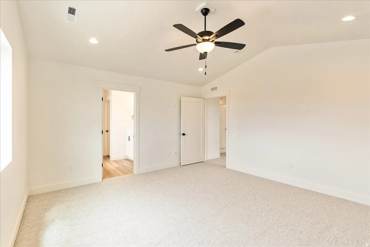 Unfurnished bedroom featuring a ceiling fan, light colored carpet, recessed lighting, and vaulted ceiling