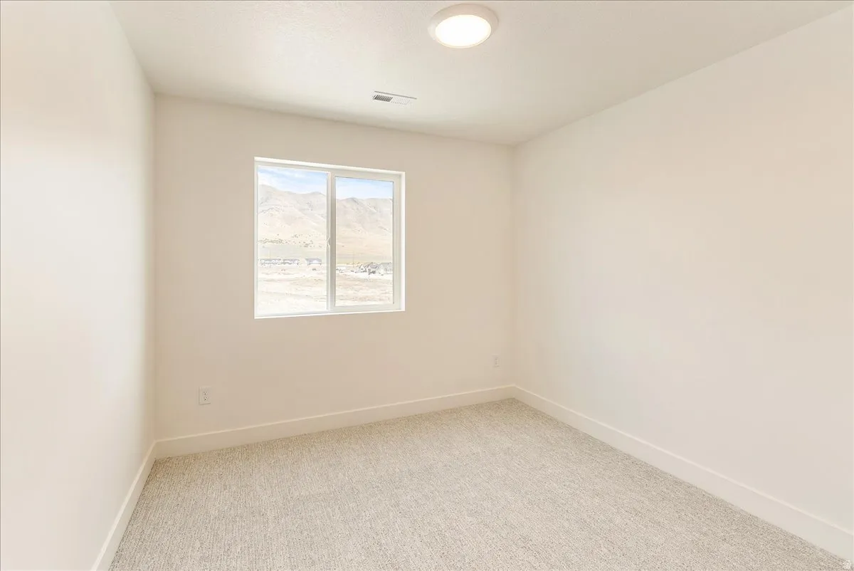 Spare room with light colored carpet and baseboards
