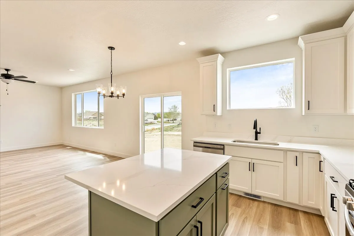 Dual tone kitchen featuring light wood-style flooring, open floor plan, a center island, dual tone cabinets, and a chandelier