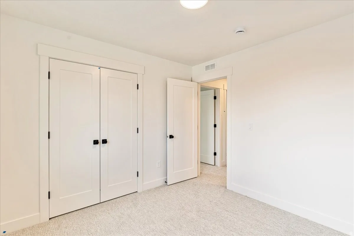 Unfurnished bedroom with light colored carpet and a closet