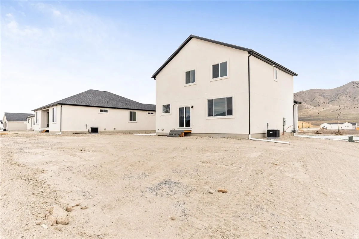 Rear view of house featuring stucco siding and a mountain view