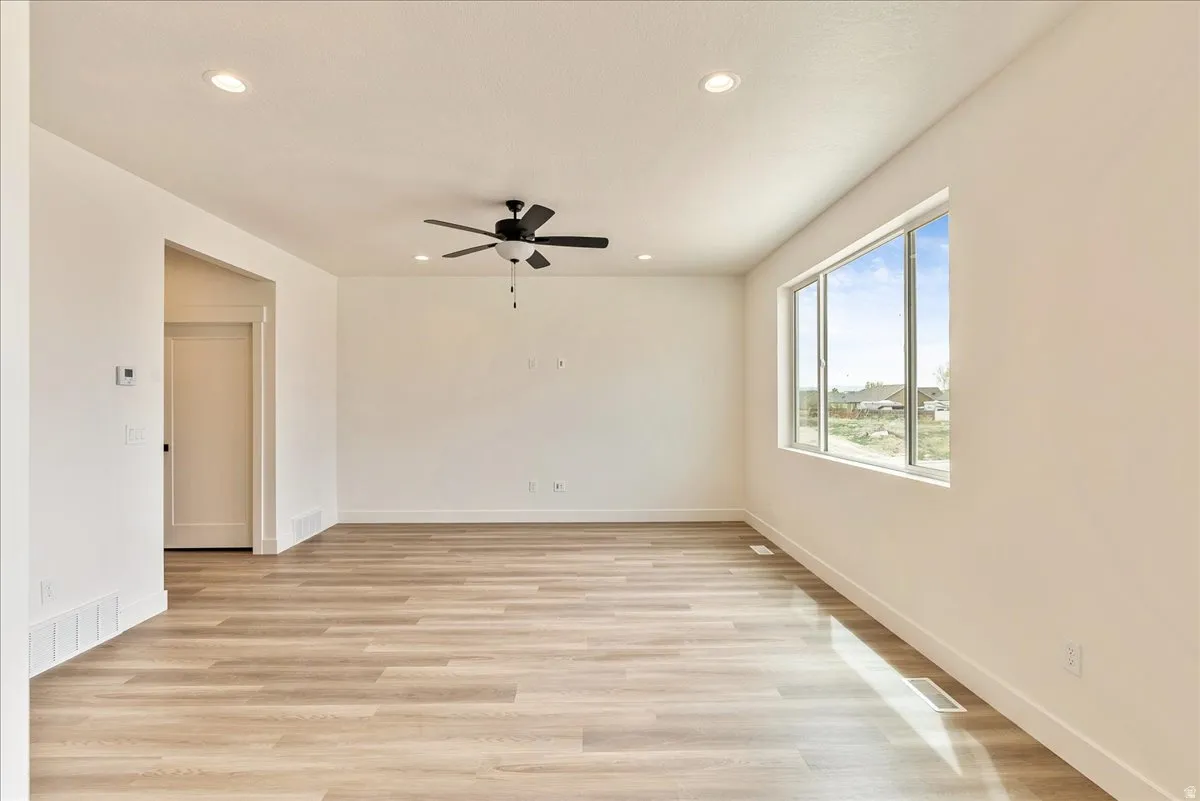 Unfurnished room featuring ceiling fan, light wood-style floors, and recessed lighting